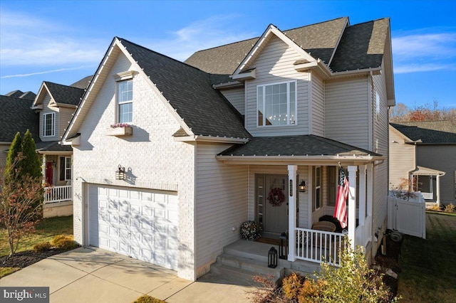 view of property with a porch and a garage