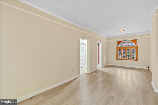 unfurnished room featuring ornamental molding and light hardwood / wood-style flooring