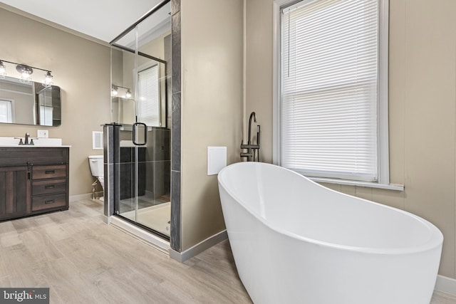 full bathroom with separate shower and tub, toilet, vanity, and hardwood / wood-style flooring