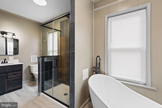 full bathroom featuring hardwood / wood-style floors, vanity, toilet, shower with separate bathtub, and a wealth of natural light