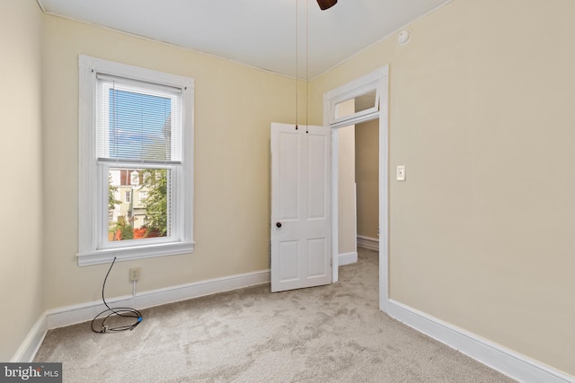 carpeted spare room featuring ceiling fan