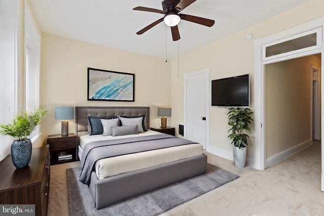 bedroom featuring light colored carpet and ceiling fan