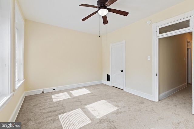 empty room with ceiling fan and light colored carpet