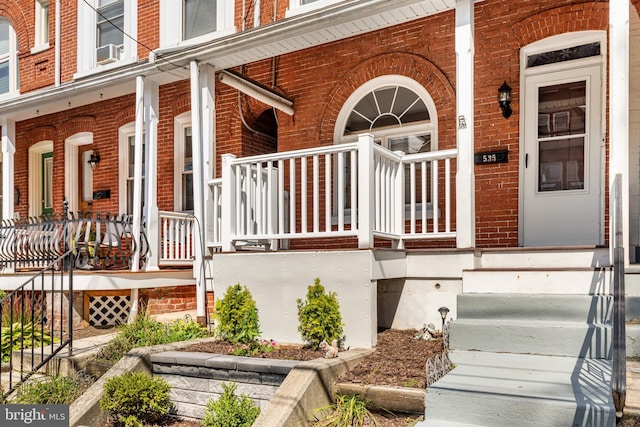 view of exterior entry with cooling unit and covered porch