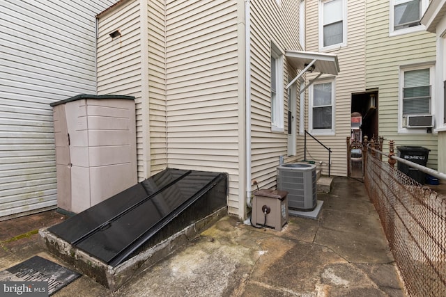 exterior space featuring central AC unit, cooling unit, and a wood stove