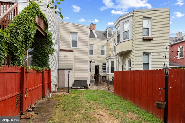 back of house featuring central AC and a yard