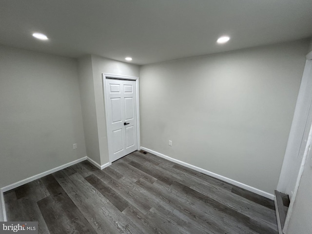 basement with dark hardwood / wood-style floors