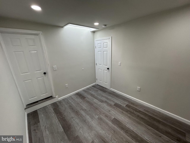 unfurnished room with dark wood-type flooring