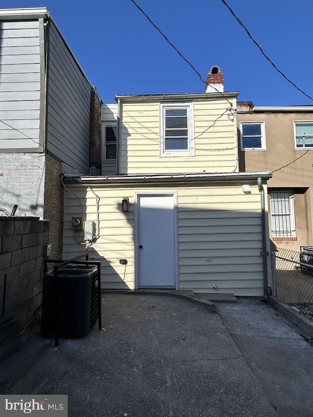 rear view of house featuring central AC