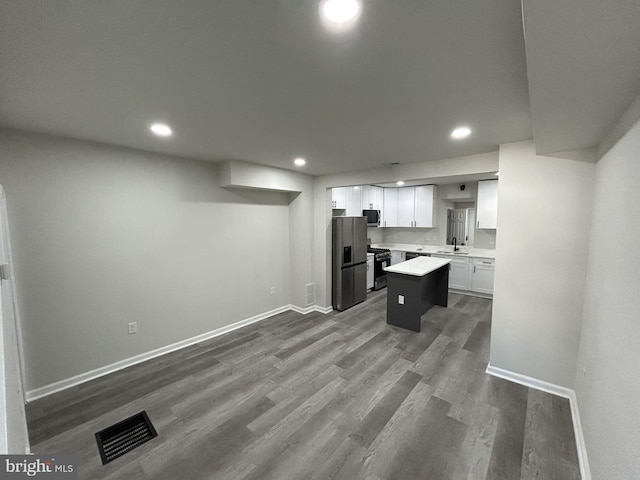 kitchen featuring a center island, white cabinets, sink, dark hardwood / wood-style floors, and appliances with stainless steel finishes