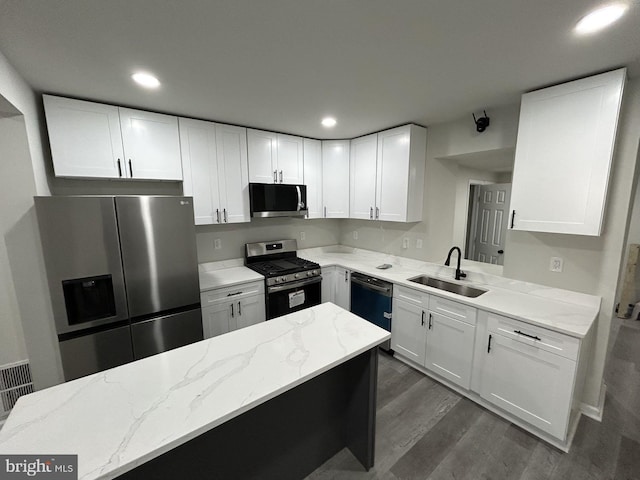 kitchen featuring sink, light stone counters, dark hardwood / wood-style flooring, white cabinets, and appliances with stainless steel finishes