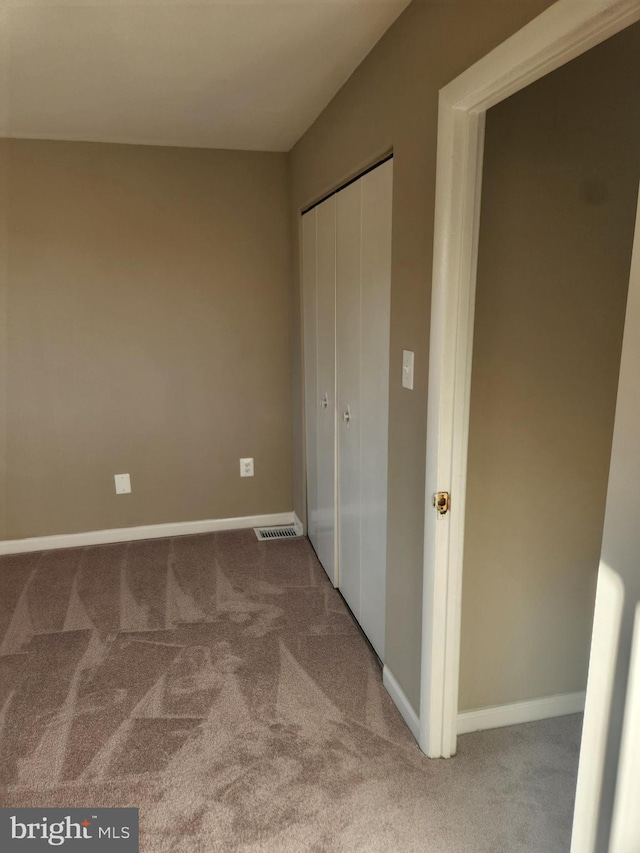 unfurnished bedroom with carpet flooring and a closet