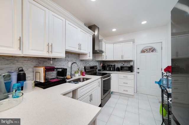 kitchen with white cabinets, sink, stainless steel range with electric cooktop, and wall chimney exhaust hood