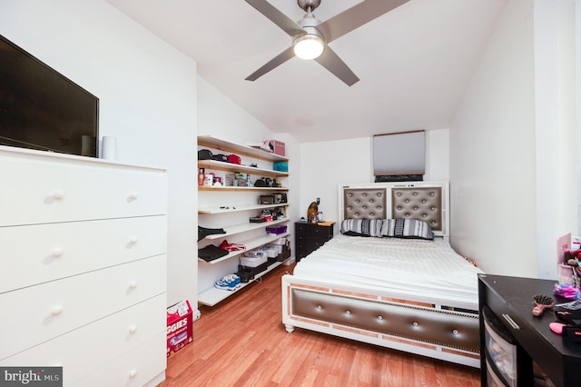 bedroom with ceiling fan, light wood-type flooring, and vaulted ceiling