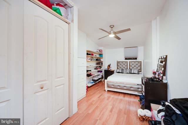 bedroom with vaulted ceiling, a closet, light hardwood / wood-style flooring, and ceiling fan