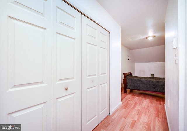 bedroom featuring a closet, vaulted ceiling, and light hardwood / wood-style flooring