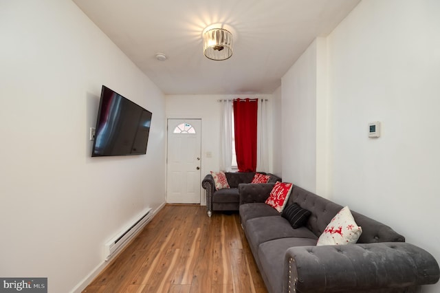 living room with baseboard heating and light hardwood / wood-style flooring