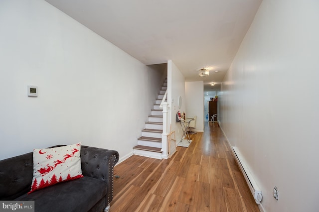 staircase featuring hardwood / wood-style floors and a baseboard heating unit