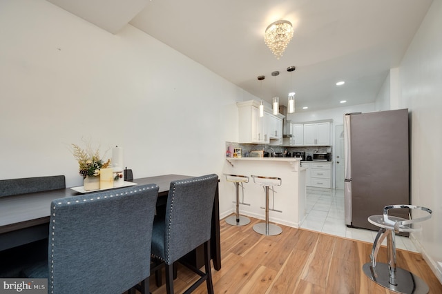 dining space featuring sink and light hardwood / wood-style flooring