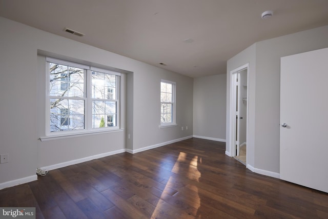 unfurnished room with dark hardwood / wood-style floors and a wealth of natural light