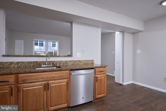 kitchen featuring stainless steel dishwasher, sink, dark stone counters, and dark wood-type flooring