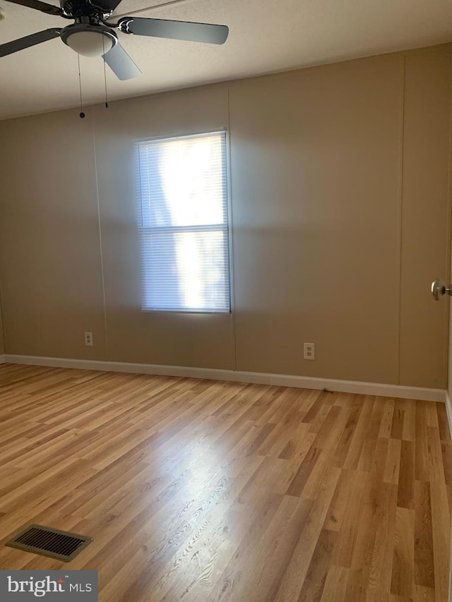 empty room with ceiling fan and light hardwood / wood-style floors