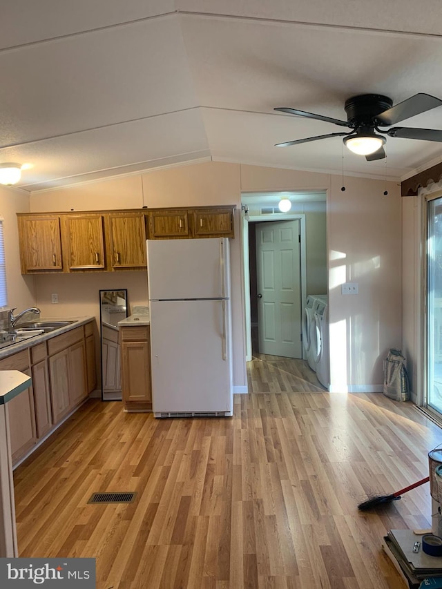 kitchen with washing machine and clothes dryer, light hardwood / wood-style floors, lofted ceiling, and white refrigerator