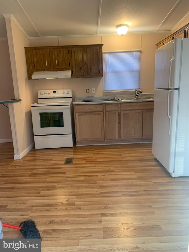 kitchen featuring white appliances, light hardwood / wood-style floors, ornamental molding, and sink