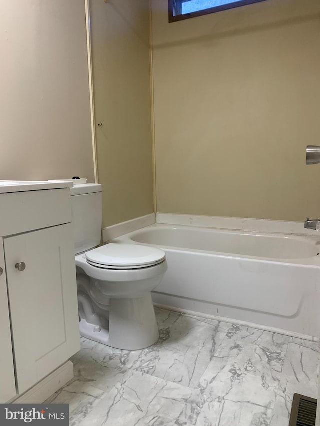 bathroom featuring a washtub, toilet, and vanity