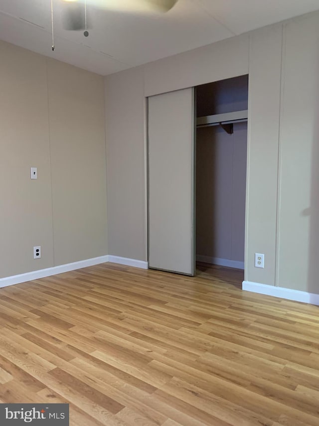 unfurnished bedroom featuring light hardwood / wood-style flooring and a closet