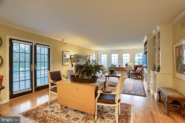 dining area with light hardwood / wood-style floors, plenty of natural light, and crown molding