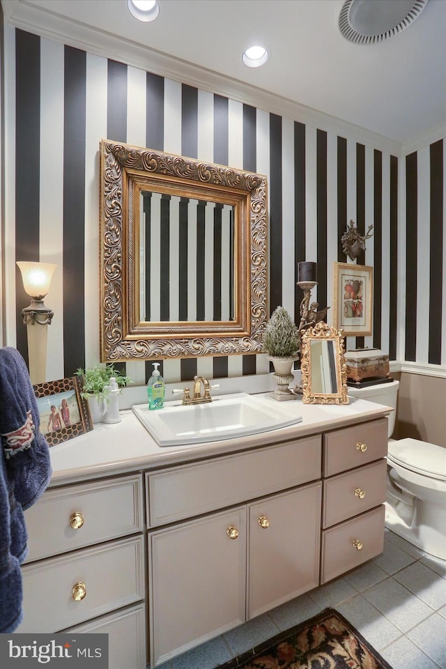 bathroom with tile patterned flooring, vanity, toilet, and ornamental molding