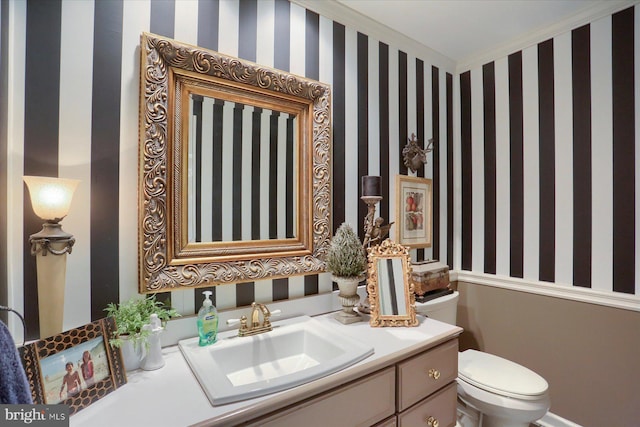 bathroom with vanity, toilet, and crown molding