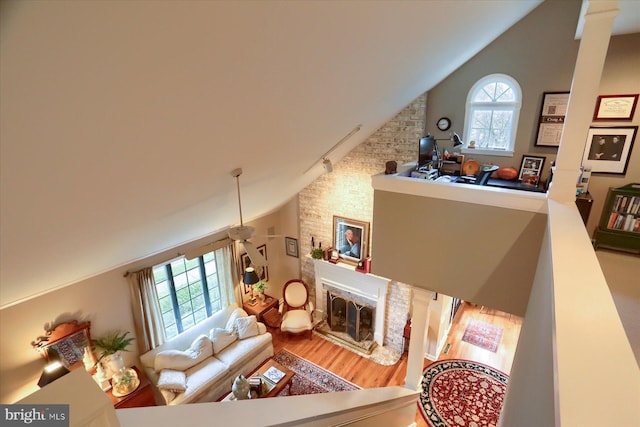 living room with hardwood / wood-style floors, a large fireplace, and high vaulted ceiling