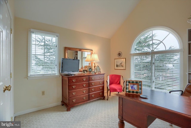 carpeted home office with lofted ceiling