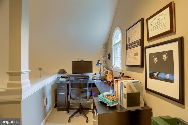 office area featuring light colored carpet, ornate columns, and lofted ceiling