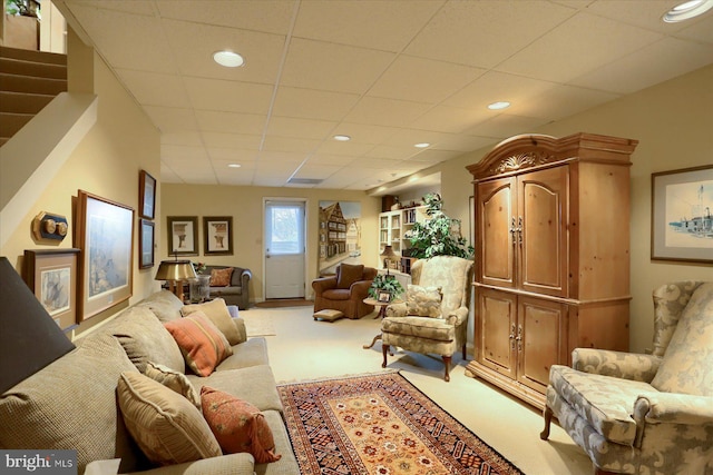 carpeted living room with a drop ceiling