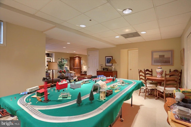 playroom with a paneled ceiling and carpet floors