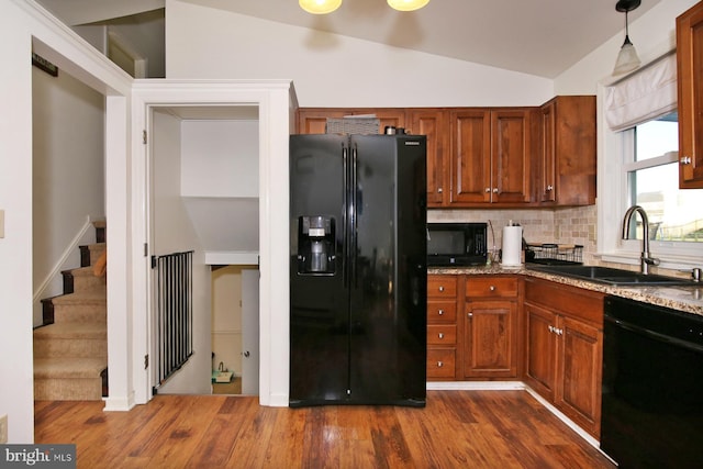 kitchen featuring dark wood-type flooring, sink, black appliances, pendant lighting, and lofted ceiling