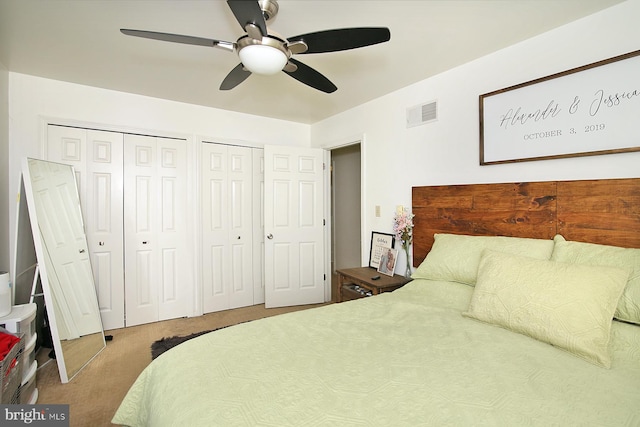 carpeted bedroom with multiple closets and ceiling fan