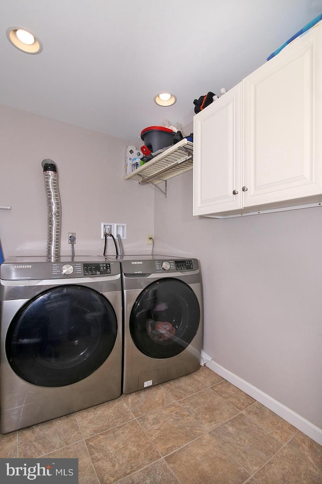 laundry area with cabinets, light tile patterned floors, and separate washer and dryer