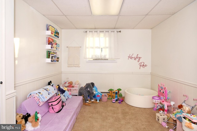 rec room featuring light carpet and a drop ceiling