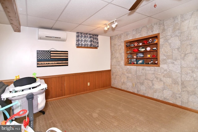 playroom with a paneled ceiling, light carpet, and a wall mounted AC