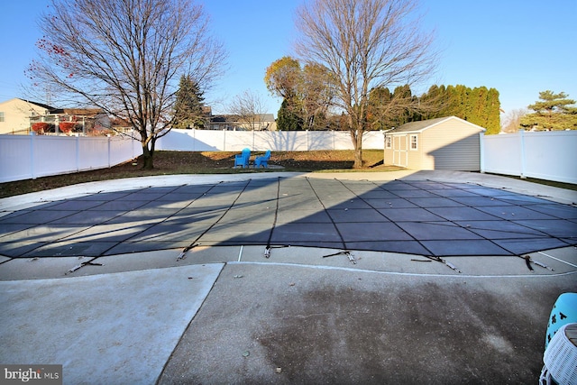 view of pool with a patio area and a shed