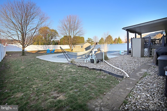 view of yard with a covered pool and a storage shed