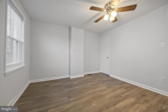 unfurnished room featuring ceiling fan and dark wood-type flooring