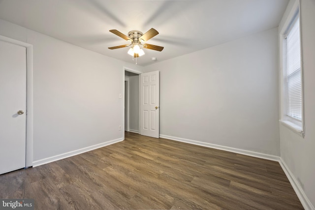 empty room with ceiling fan and dark hardwood / wood-style flooring