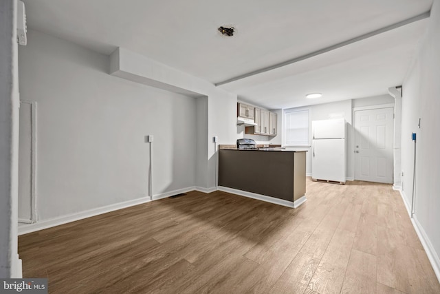 kitchen with white cabinets, white refrigerator, light wood-type flooring, and kitchen peninsula