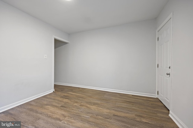 empty room with dark hardwood / wood-style flooring