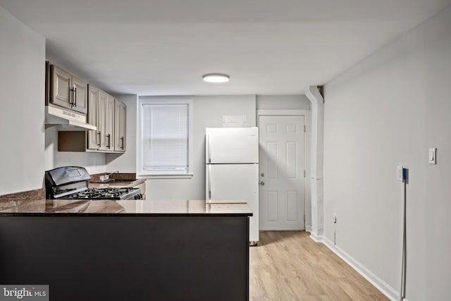 kitchen featuring kitchen peninsula, light hardwood / wood-style flooring, black range, and white refrigerator